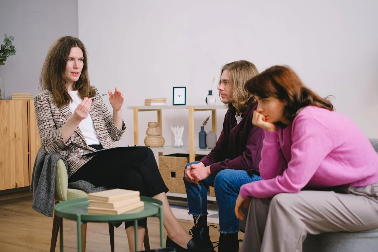 heros-img A counselor having a discussion with two students in an inviting, modern interior space.